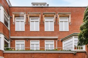 Fachada renovada de una casa con ventanas blancas